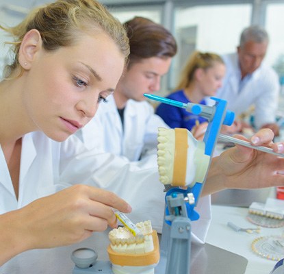 A dental technician working on a denture