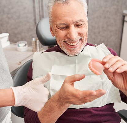 A dentist showing dentures to her patient